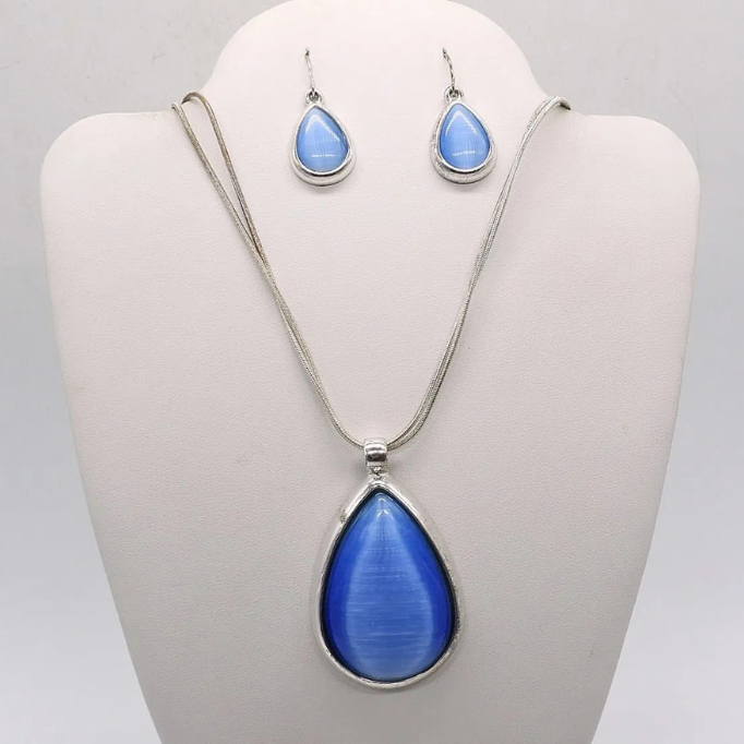Sterling silver jewelry set with a teardrop-shaped blue pendant necklace and matching blue teardrop earrings